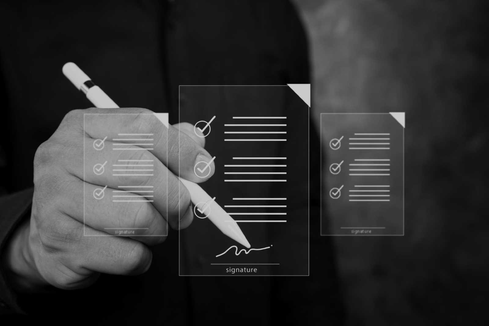 Person unterschreibt Vertrag; digitale Checklisten-Icons über dem Signaturdokument – elektronik, embedded dienstleister.