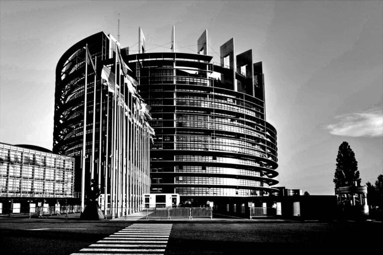 Modernes, kreisförmiges Bürogebäude mit Flaggen – idealer Standort für embedded dienstleister