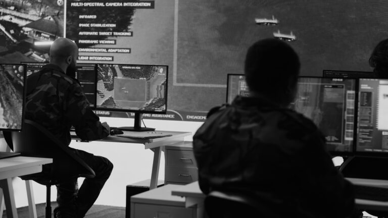 Arbeitsstation mit mehreren Monitoren und Großbildschirm zeigt Überwachungsdaten – embedded software und elektronik