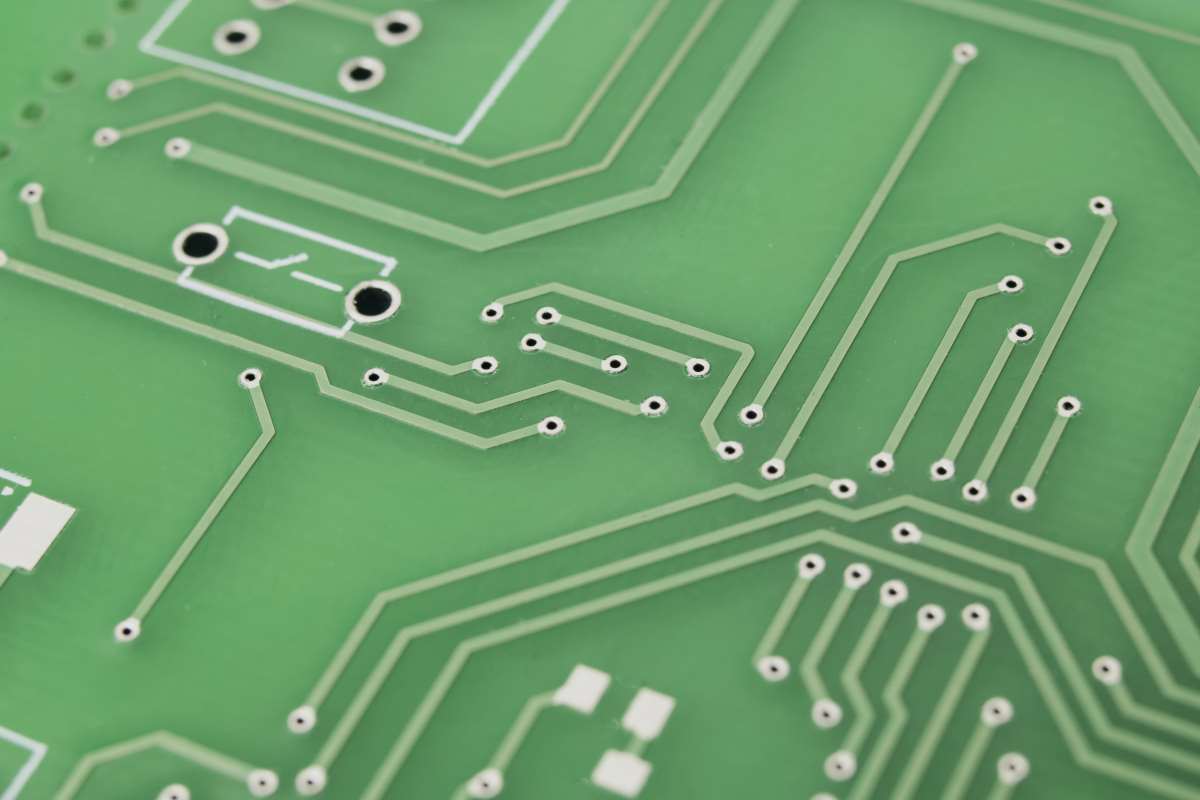 Grüne Leiterplatte mit feinen Leiterbahnen; Elektronik und embedded hardware im Fokus.