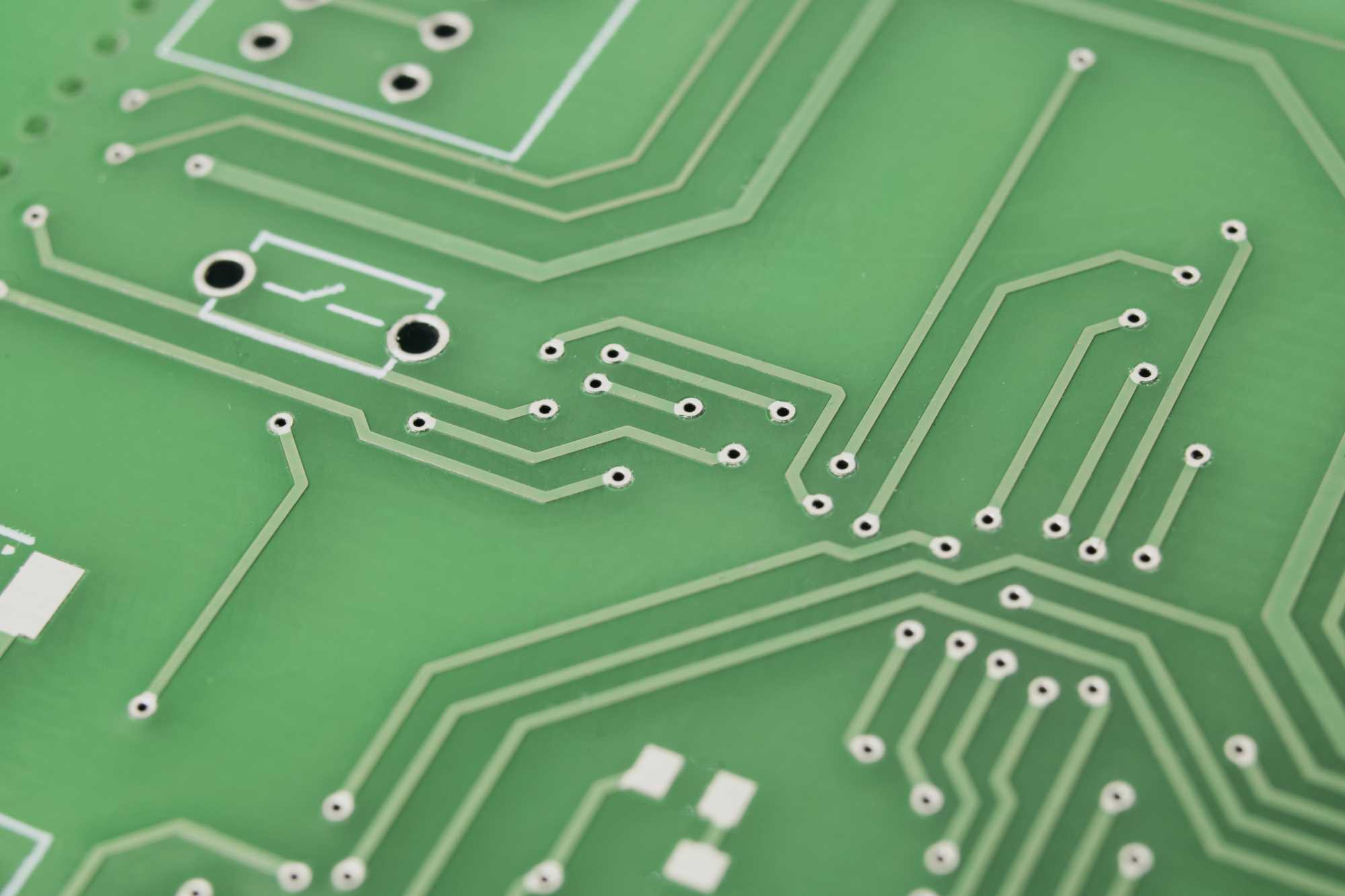 Nahaufnahme einer grünen Leiterplatte mit Leitungen – hochwertige elektronik, embedded hardware.