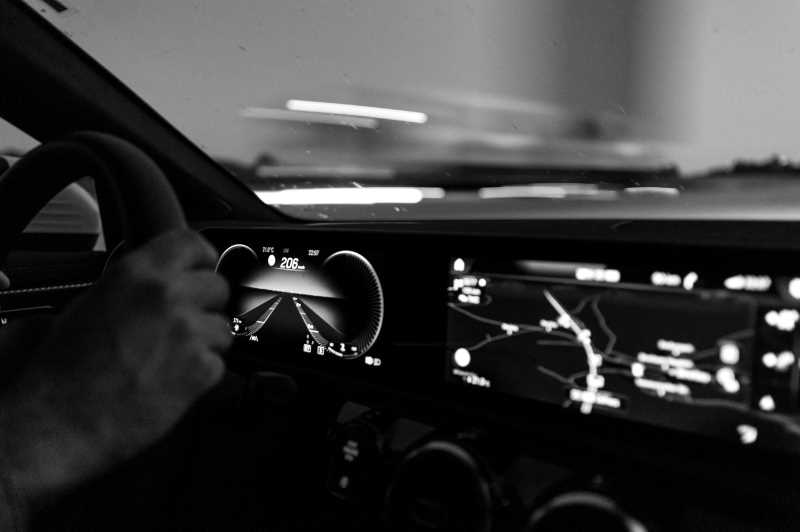Innenaufnahme eines Autos mit digitalem Cockpit und Navigationsdisplay.