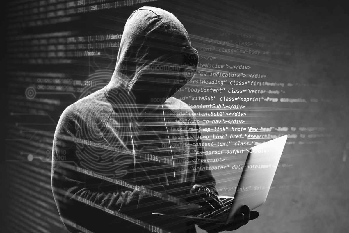Hacker im Hoodie mit Laptop, Code-Overlay - Fokus auf embedded software.